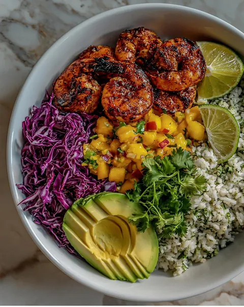 Blackened shrimp bowl with mango, red cabbage and avocado